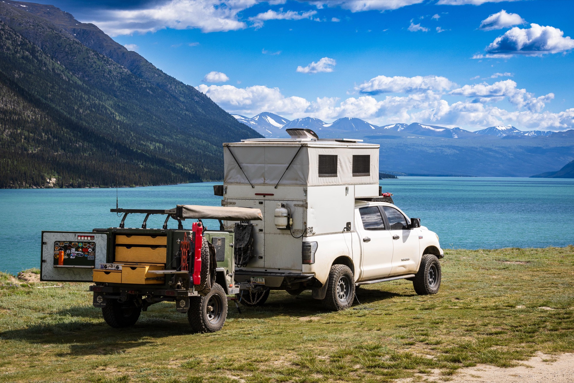 Turtleback Expedition above a turquoise glacial lake with snow-capped peaks