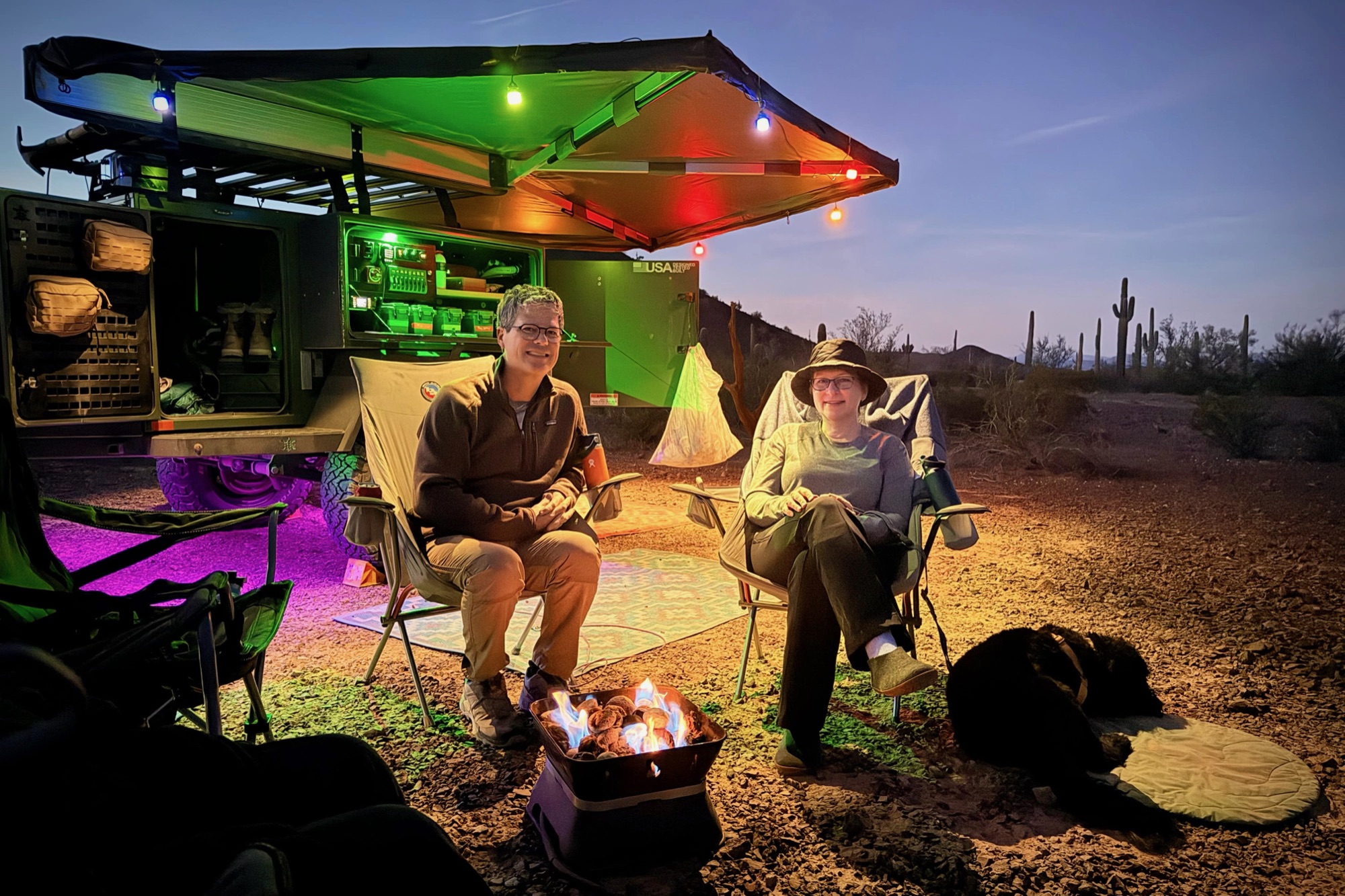 Evening campfire, awning out, lights glowing