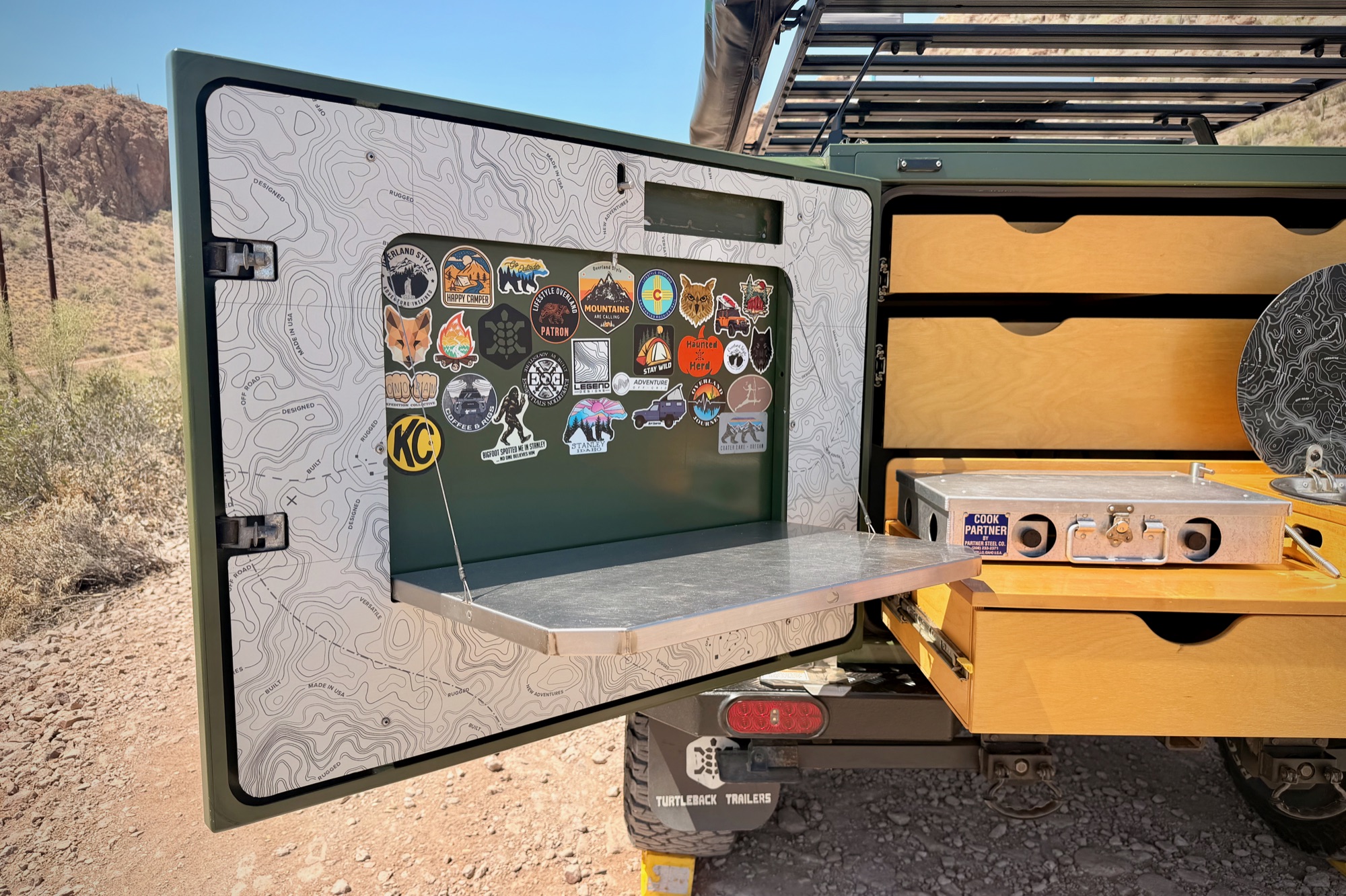 Side door drops to a table — trail-earned stickers
