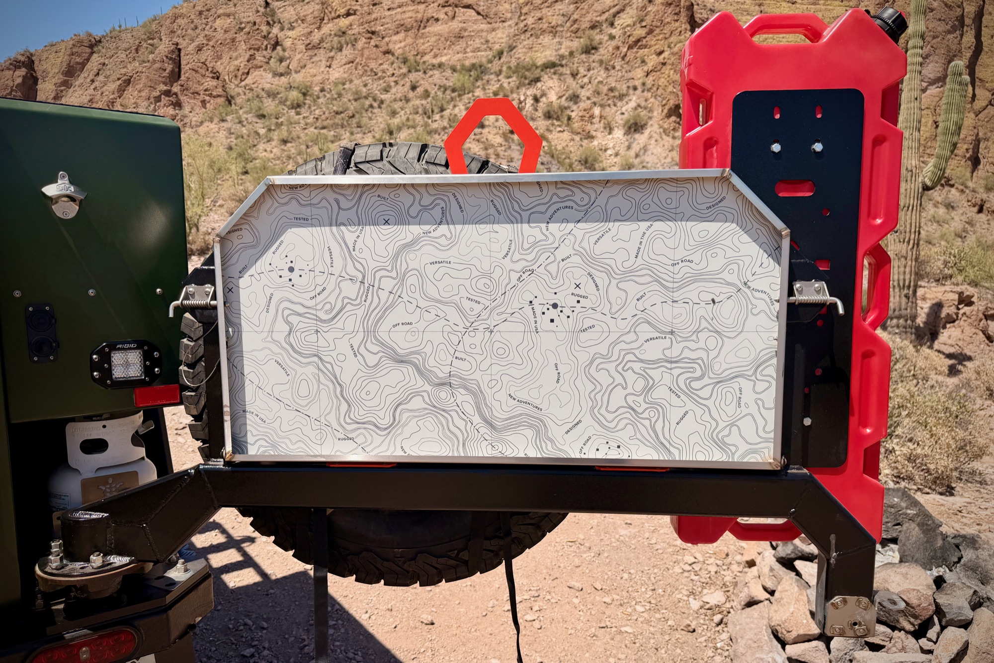 Rear swing-arm open — spare carrier and topo-lined door