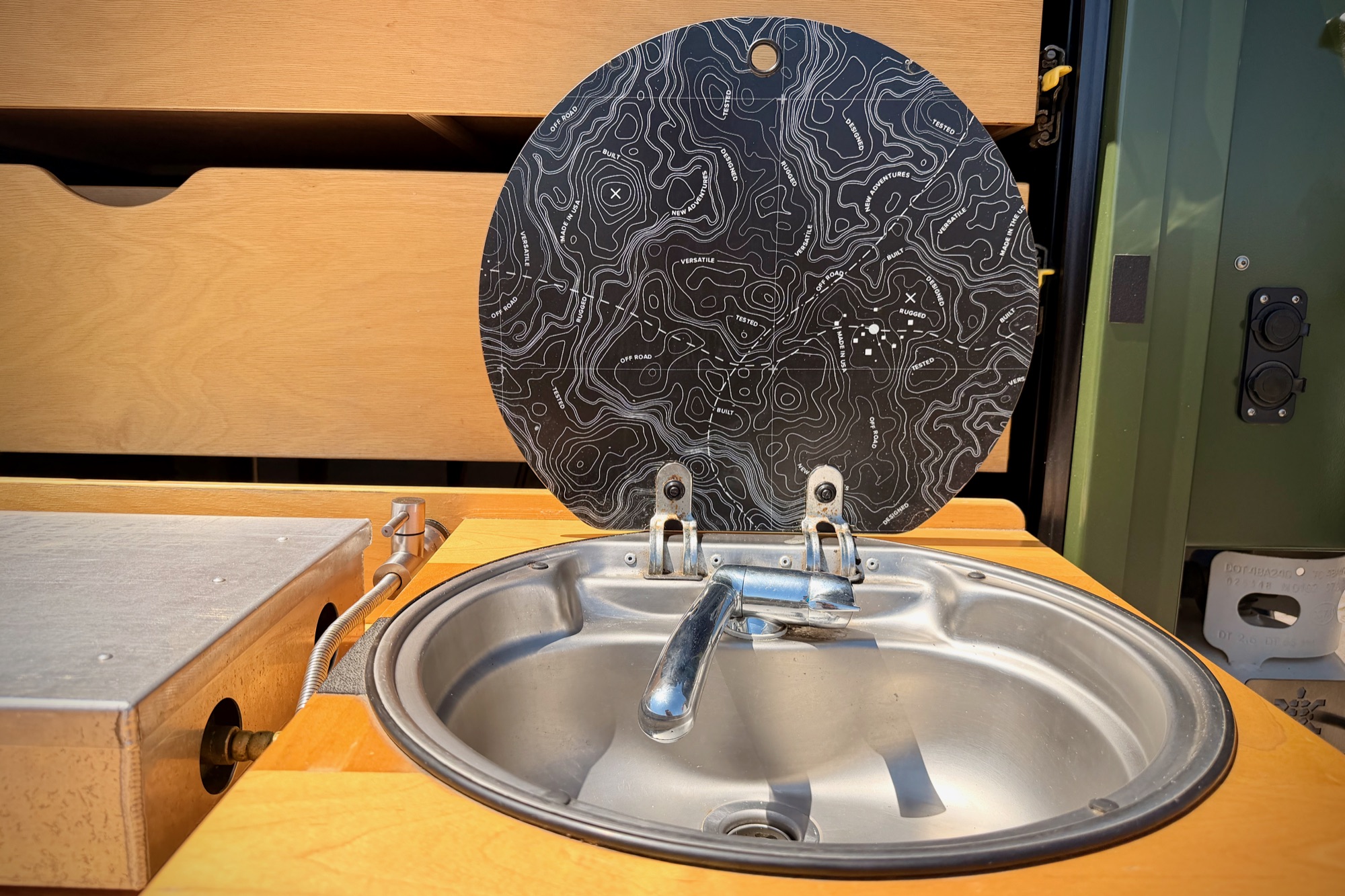 Galley sink with its topo-map cover lifted